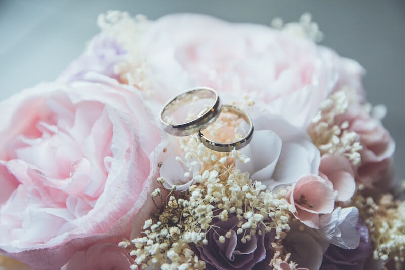 wedding rings atop flowers